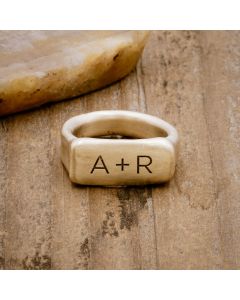 a 14k yellow gold Make Your Mark Signet Ring, personalized with monogram, on wood background