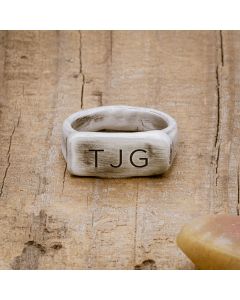 an antiqued sterling silver Make Your Mark Signet ring, personalized with monogram, on wood background