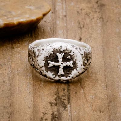 Ancient Cross Signet Ring, handcrafted in sterling silver, sitting on a wood background 