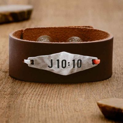 Brown Identity Verse Leather Cuff sitting on wood