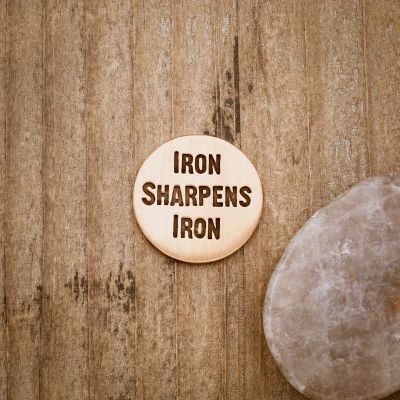 Personalized Bronze Iron Sharpens Iron Golf ball marker on wood background