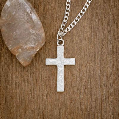 Redemption Cross Necklace, handcrafted in pewter, on a wood background
